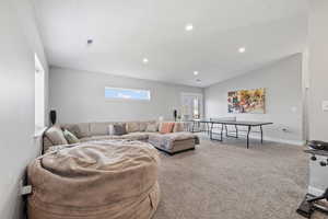 ADU second floor rec room/living room with vaulted ceilings, light colored carpet, recessed lighting and two-tone paint