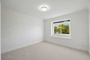 Unfurnished bedroom with light carpet and custom roller shades