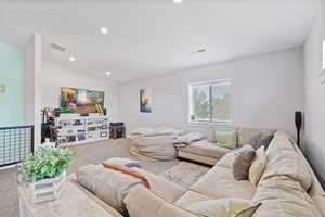 ADU second floor rec room/living room with vaulted ceilings, light colored carpet, recessed lighting and two-tone paint