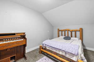 ADU Carpeted bonus room featuring vaulted ceiling and two-tone paint