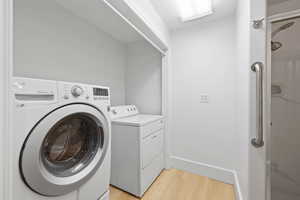 Basement laundry room featuring free standing washer and dryer and LVP flooring