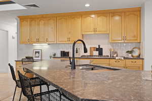 Kitchen with stainless steel appliances, recessed lighting, a large island, quartz countertops and custom backsplash