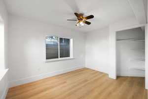 Basement bedroom with light LVP flooring, a closet, and ceiling fan
