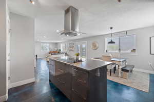 ADU kitchen island featuring quartz countertops, electric cooktop and stainless steel range hood