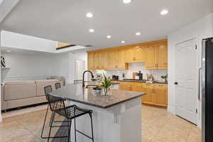 Kitchen with stainless steel appliances, recessed lighting, a large island, quartz countertops and custom backsplash