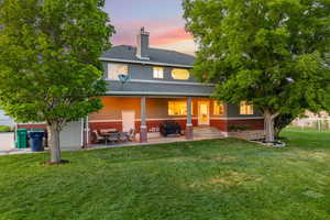 Rear view of property with a covered back patio and spacious yard