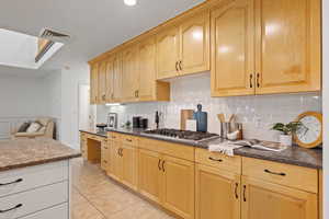 Kitchen with stainless steel appliances, recessed lighting, a large island, quartz countertops and custom backsplash