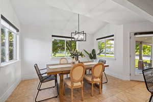 Dining space featuring a modern traditional chandelier, lofted ceilings, surrounded by windows with custom roller shades