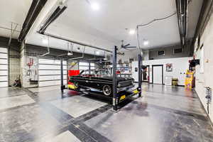 View of finished shop with bar, bathroom, and car lift