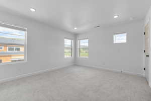 Unfurnished room with light carpet, baseboards, and recessed lighting