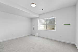 Empty room with light colored carpet and baseboards