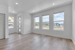 Unfurnished room featuring baseboards, recessed lighting, and light wood finished floors