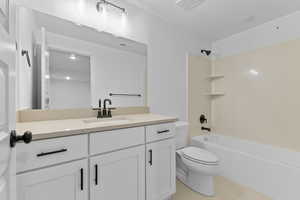 Bathroom with toilet, tile patterned flooring, vanity, and tub / shower combination