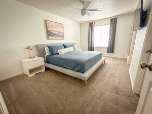 Master Bedroom with light carpet, a textured ceiling, baseboards, and a ceiling fan