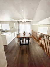 Dining room with dark wood-style flooring and healthy amount of natural light