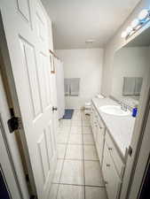 Master bathroom featuring a textured ceiling, vanity, toilet, tile patterned floors, and baseboards