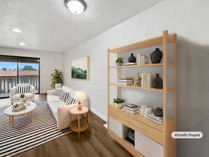 Living area with dark wood-type flooring, baseboards, and recessed lighting