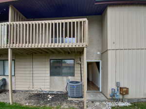 Back of property featuring a balcony and central AC unit