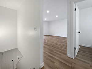 Corridor featuring wood finished floors, recessed lighting, and baseboards