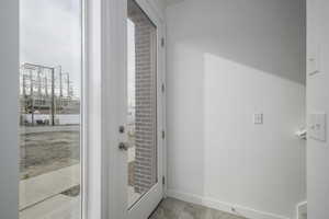 Doorway to outside featuring baseboards