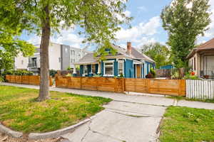 View of property exterior, a fenced front yard, and a driveway gate