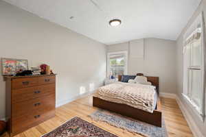 Spacious bedroom with hardwood floors and two-tone paint