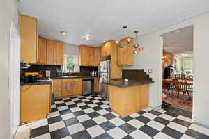 Kitchen with stainless steel appliances, light wood cabinets, and tile floors