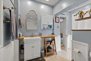 Full bathroom featuring a wainscoted wall, toilet, tiled shower / tub combo