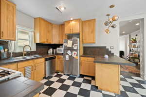 Kitchen with stainless steel appliances, light wood cabinets, and tile floors