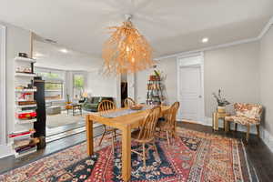 Open concept dining space with feature chandelier, hardwood floors, and two-tone paint