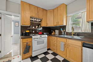 Kitchen with stainless steel appliances, light wood cabinets, and tile floors
