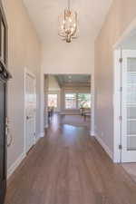 Entryway featuring a chandelier, wood finished floors, and baseboards
