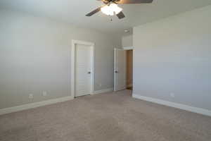 Unfurnished bedroom featuring baseboards, light carpet, and a ceiling fan