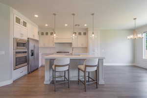Kitchen featuring stainless steel appliances, a sink, backsplash, light countertops, and baseboards