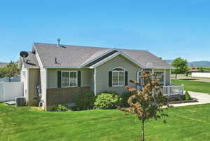 Back of property with central air condition unit and roof with shingles