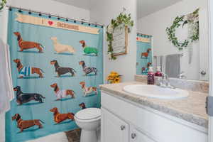 Full bath tub/shower combination, white vanity and tile floors