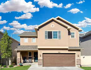 Front view of home featuring stucco and stone.