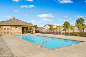 Community pool featuring a patio area, a residential view, and fence