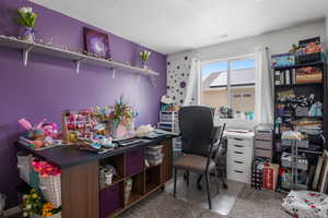 Home office featuring large window and carpet flooring
