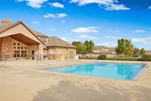 Community pool featuring a patio area and fence