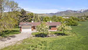 View of front of house featuring an attached garage, driveway, brick siding, and a front yard