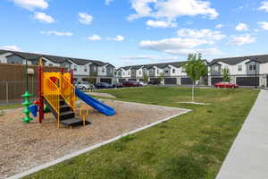 Community jungle gym with a residential view and a lawn
