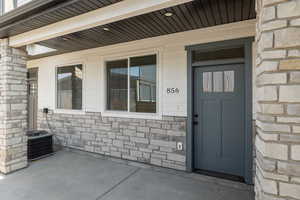Property entrance with cooling unit and stone siding