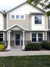 View of front of house with board and batten siding and stone siding