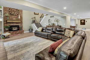 Living area featuring wood finished floors, stairway, crown molding, recessed lighting, and baseboards