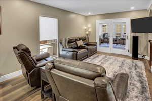 Living area with wood finished floors, baseboards, recessed lighting, and french doors