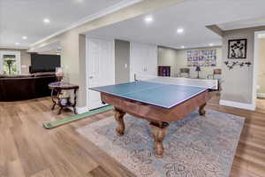 Game room featuring crown molding, wood finished floors, baseboards, and recessed lighting