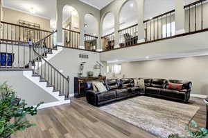 Living room featuring wood finished floors, stairway, a high ceiling, and a wonderful open feel!