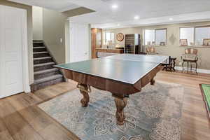 Playroom with light wood finished floors, baseboards, and recessed lighting