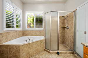 Full bath with a shower stall, a bath, vanity, and tile patterned floors